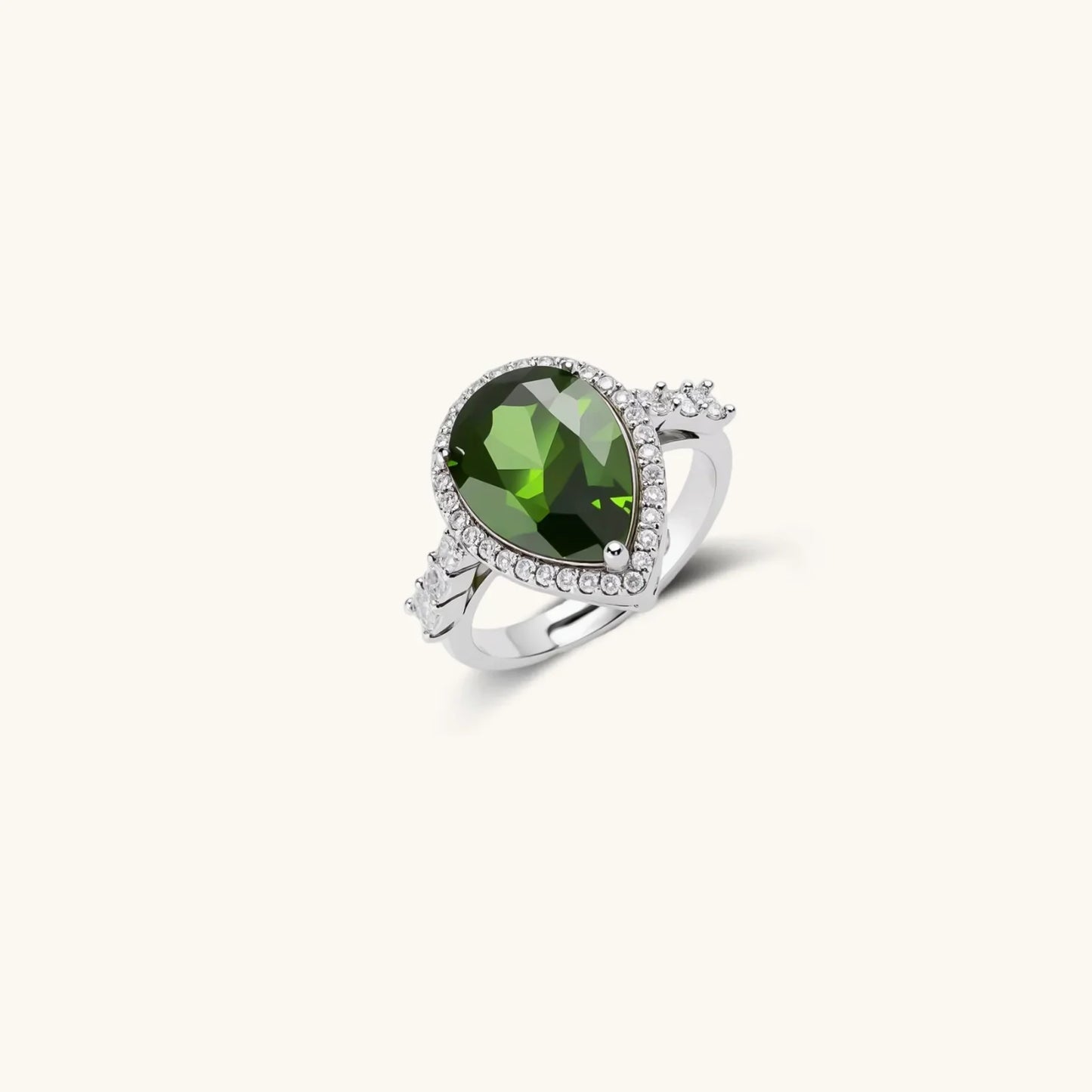 Elegant green gemstone ring with diamond halo, silver band, perfect for luxury gifts or home décor accents.