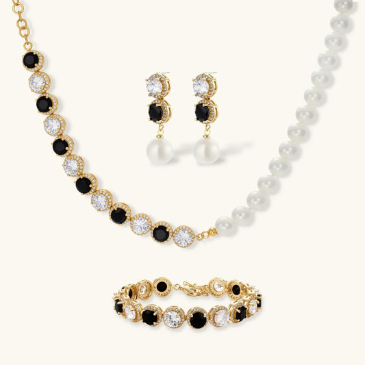Elegant gold jewelry set with black and clear crystals, pearl accents, necklace, earrings, and bracelet
