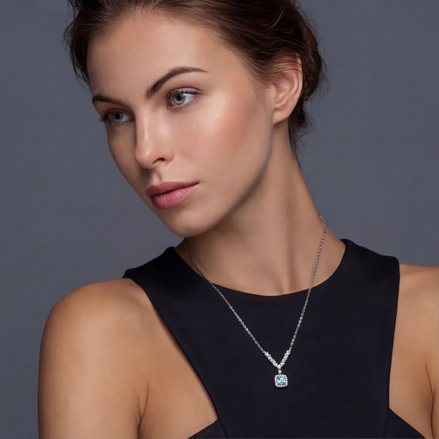 Elegant woman wearing a silver necklace with a square blue gemstone pendant, perfect for sophisticated home styling.