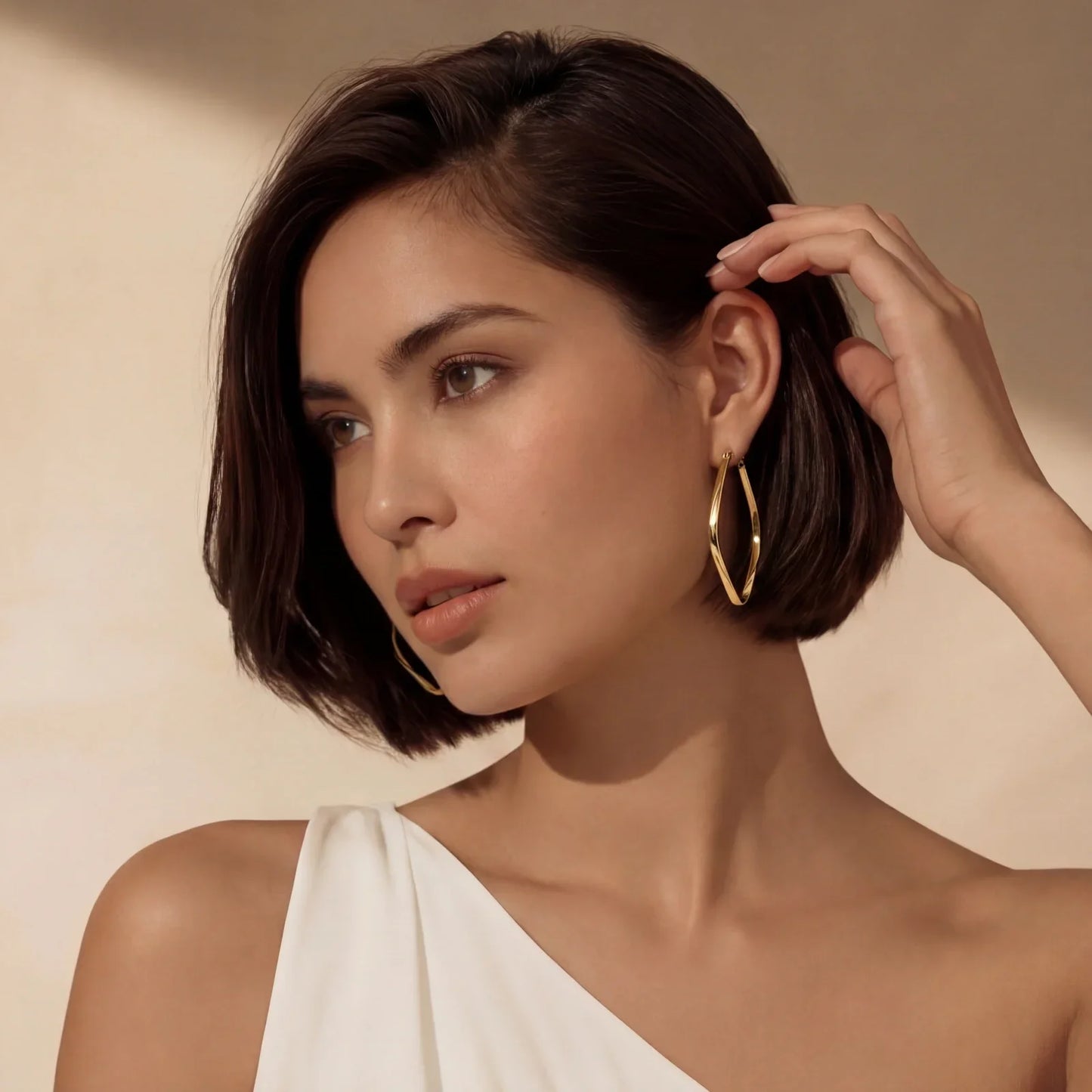Woman wearing gold hoop earrings, elegant minimalist style