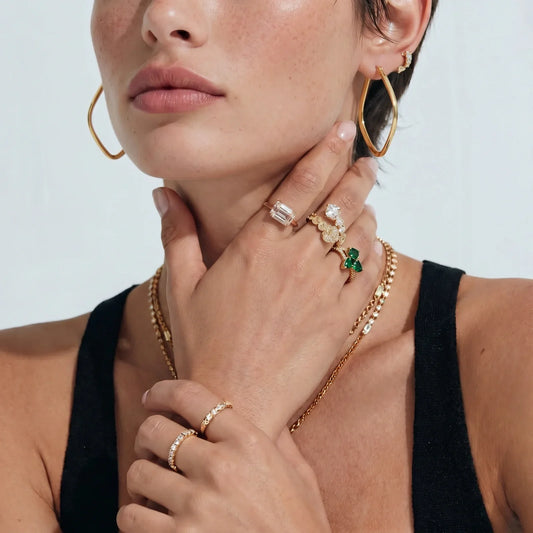 Elegant gold hoop earrings, emerald rings, and layered necklaces styled for modern Australian home décor lovers.