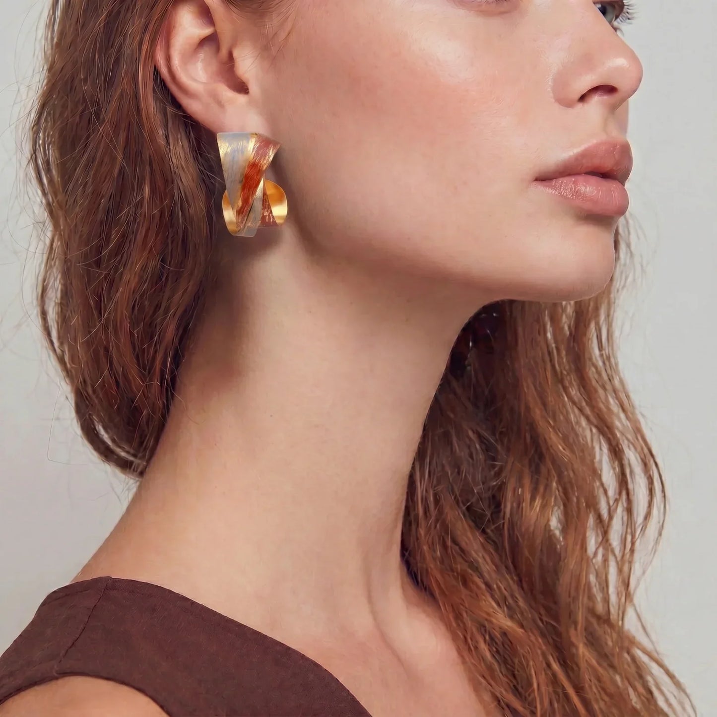 Modern gold statement earrings with amber swirls, styled for elegant home décor and unique gifts