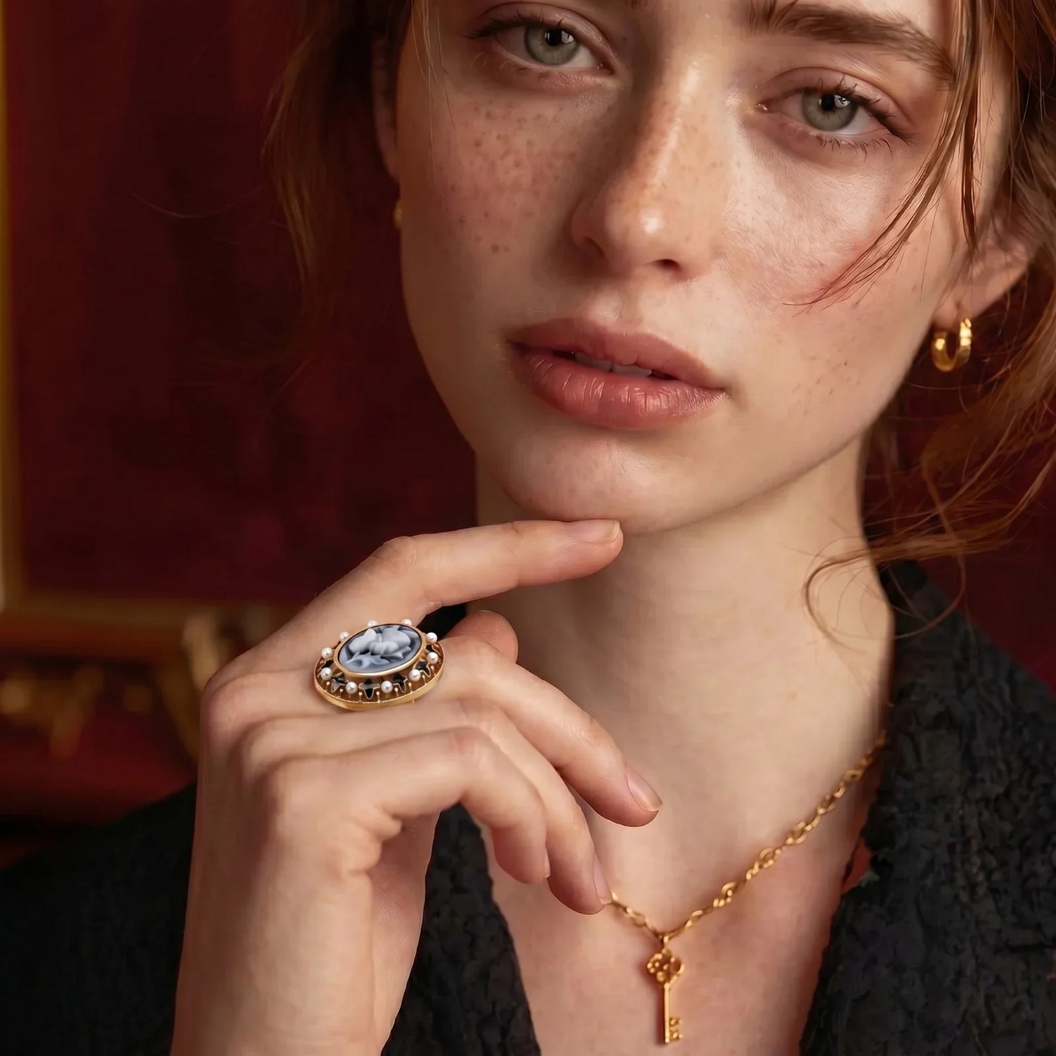 Elegant gold cameo ring with pearl accents, styled with key necklace for vintage-inspired fashion.
