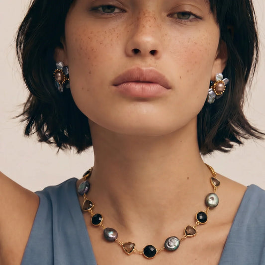 Elegant gold necklace with black and pearl beads, paired with matching floral earrings for stylish home décor gifting.