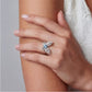 Elegant flower-shaped ring with blue gemstone and diamond accents on woman's hand