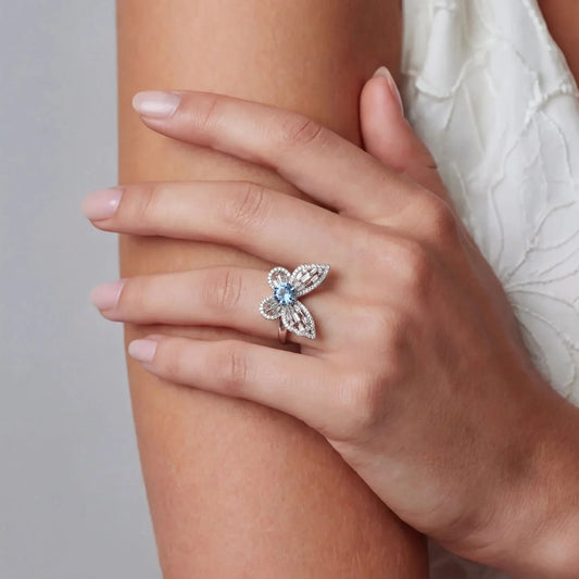 Elegant flower-shaped ring with blue gemstone and diamond accents on woman's hand