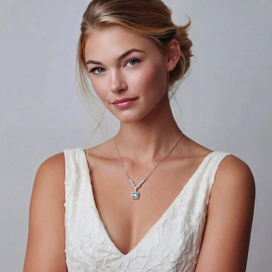 Elegant woman in white lace dress wearing a sparkling pendant necklace with blue gemstone