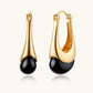 Gold hoop earrings with black teardrop accents, modern minimalist jewelry design