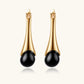 Elegant gold drop earrings with black onyx teardrop stones, modern luxury jewelry