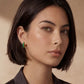 Woman wearing green gemstone hoop earrings, stylish home decor accessory