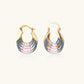 Gold hoop earrings with gradient blue-to-pink enamel in ribbed fan design on beige background