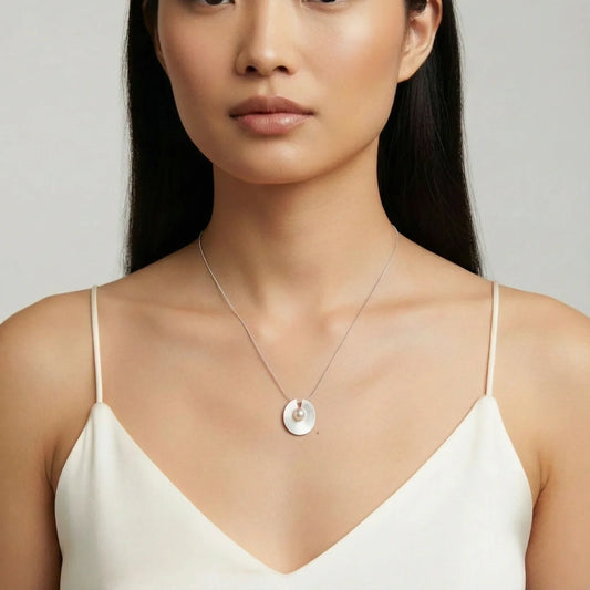 Elegant pearl pendant necklace on woman, minimalist silver disc design, perfect for stylish home décor gifts