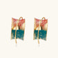 Gold-plated hoop earrings with teal and coral enamel brushstroke design on cream background