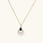 Gold necklace with pearl pendant, blue gemstone, and crystal accents for elegant home décor gifting