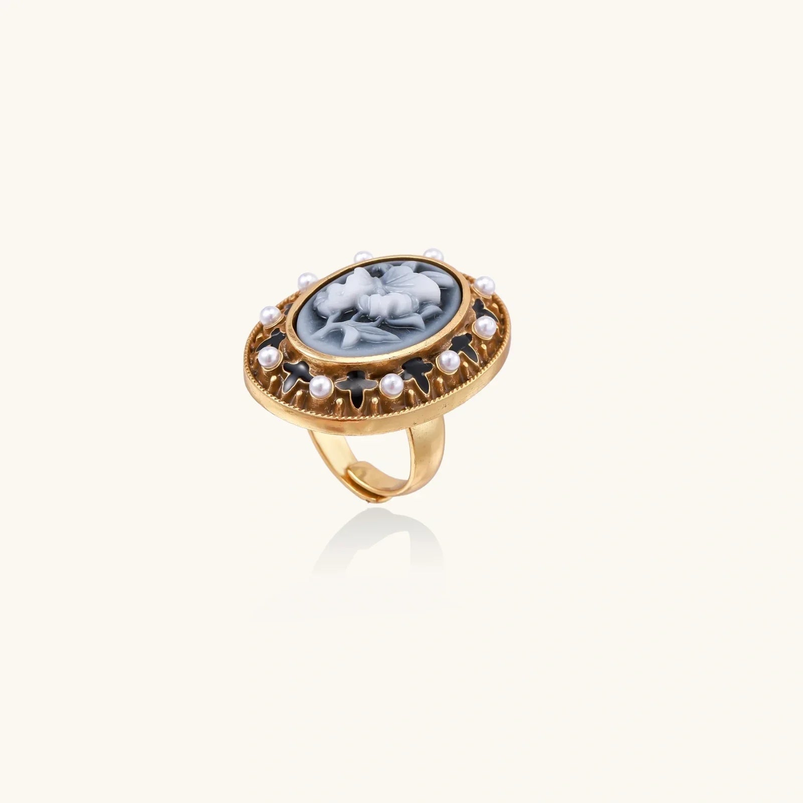 Elegant gold ring with floral cameo and pearl accents, vintage-inspired statement jewelry