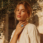 Woman wearing vintage-style cameo ring and pearl earrings, styled for boho home décor