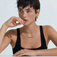 Woman wearing gold layered necklaces, hoop earrings, and a statement ring, styled for modern home décor
