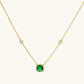 Delicate gold chain necklace featuring square emerald pendant with crystal halo and station accents