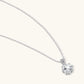 Platinum-plated sterling silver necklace with round clear crystal pendant and decorative bail on neutral background.