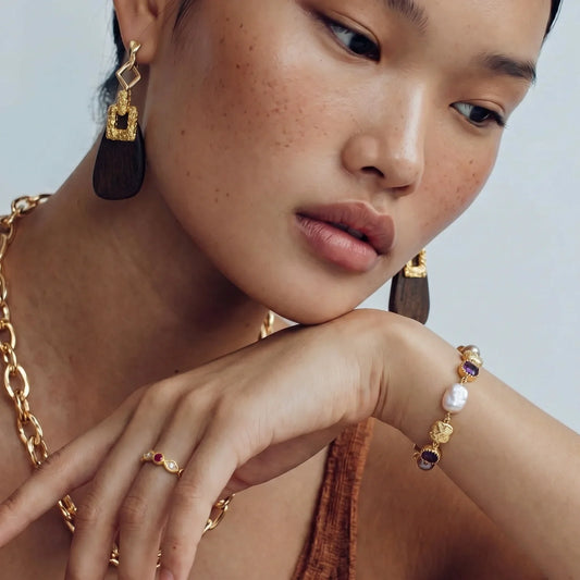 Elegant gold jewelry set with gemstone earrings, ring, and bracelet for stylish home décor gifting