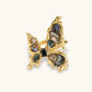 Gold butterfly ring with iridescent abalone shell wings and black gemstone center, elegant home décor accent.
