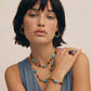 Boho turquoise and amber beaded necklace, hoop earrings, and statement ring for stylish home décor lovers