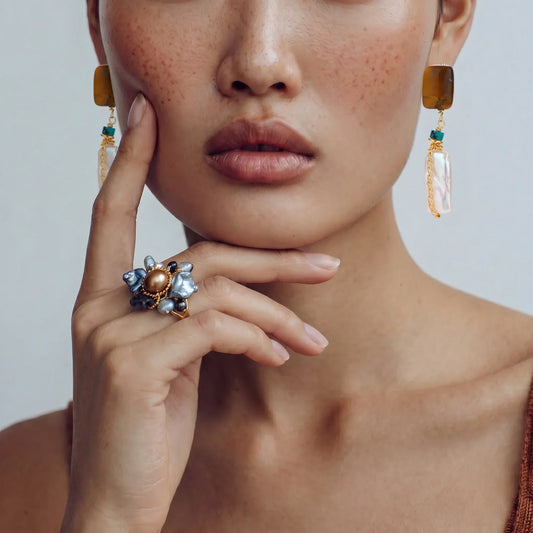 Elegant statement earrings with amber, pearl, and turquoise, paired with a floral pearl ring for chic accessorizing.