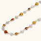 Elegant pearl and amber teardrop necklace with gold accents, perfect for stylish home décor or gifting.
