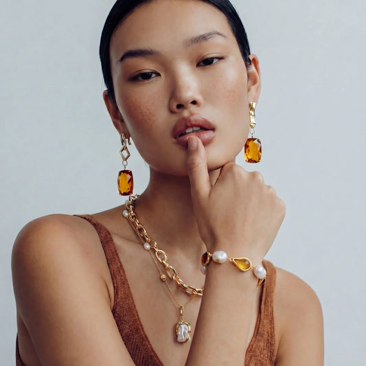 Gold statement earrings with amber gems, pearl necklace & bracelet set for elegant home décor styling