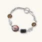 Chain bracelet with amber stones, baroque pearl, and dark rectangular stone on white gold-plated copper base.
