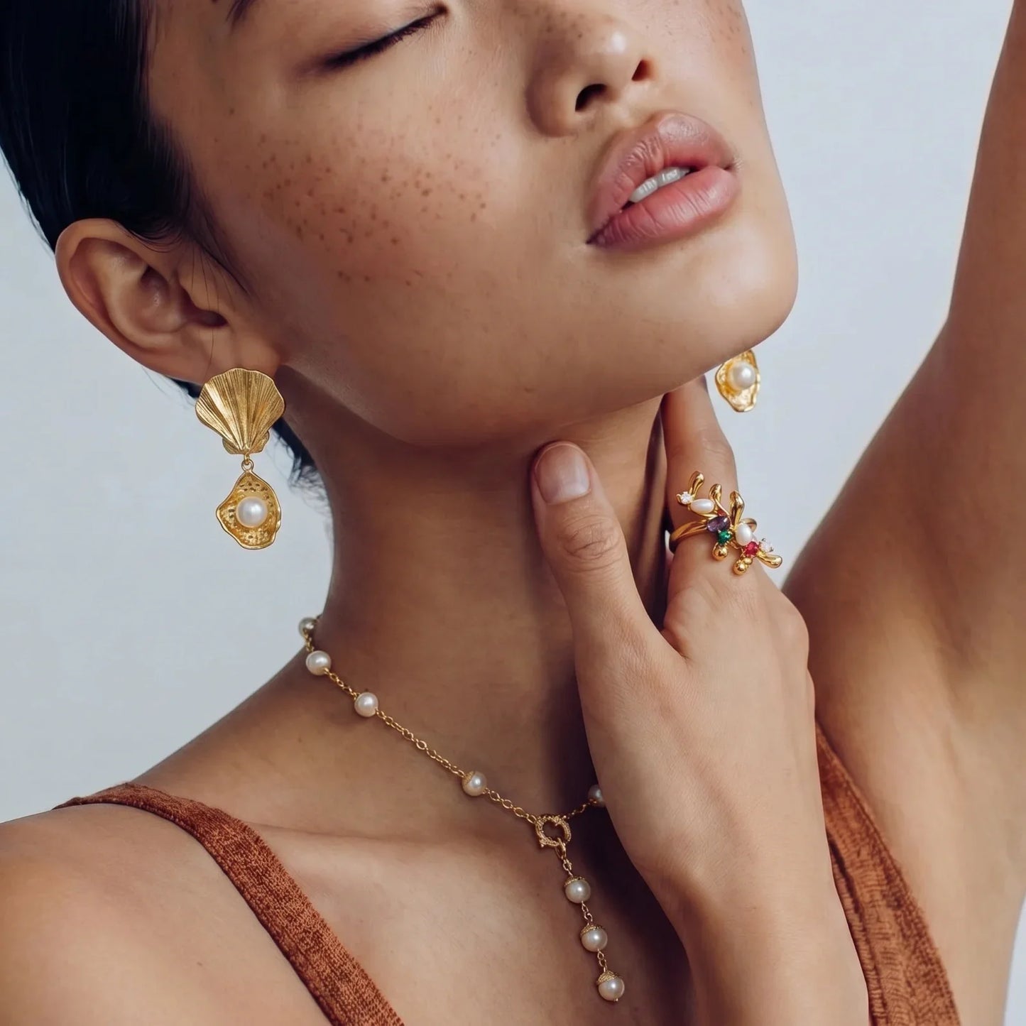 Elegant gold shell earrings, pearl necklace, and floral ring for women's luxury jewelry collection