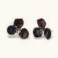 Dark iridescent baroque pearls arranged in flower pattern with 18K gold-plated center on cream background.