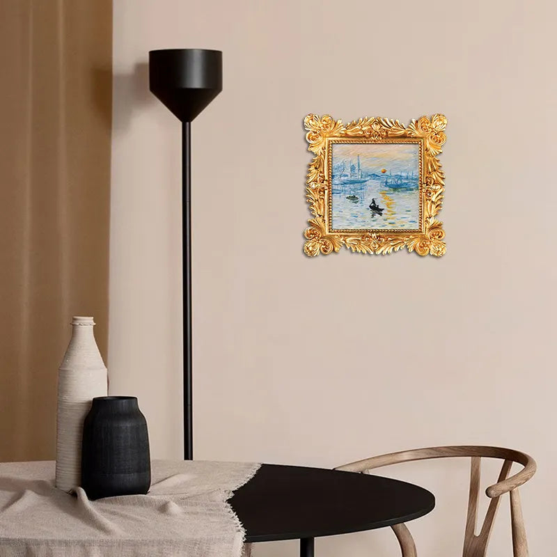 Modern dining area with artisan decor, featuring ornate gold-framed artwork on beige wall.