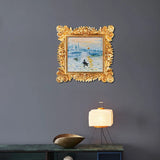 Gold ornate framed wall art above side table with lamp in modern home decor setting