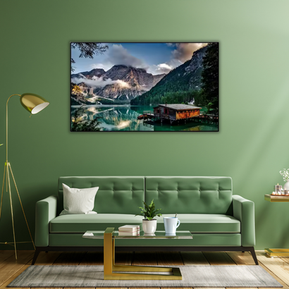 Modern living room with green sofa, wall art of mountain lake landscape, stylish home decor