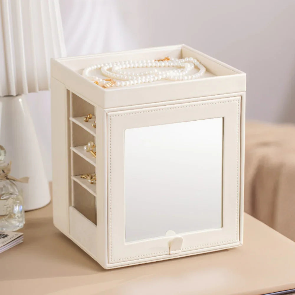 Elegant cream jewelry box with mirror, pearl necklace, and organized earring storage on table