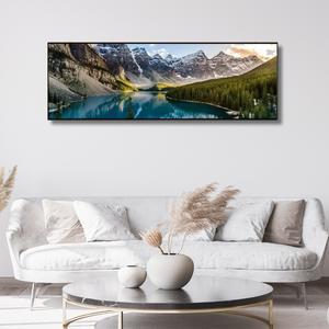 Modern living room with white sofa, round coffee table, and mountain landscape wall art