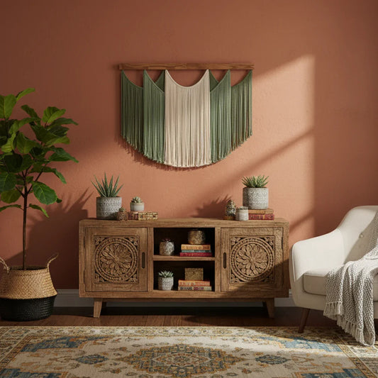 Boho artisan home decor setting with wooden sideboard, green macrame wall art, and potted plants.